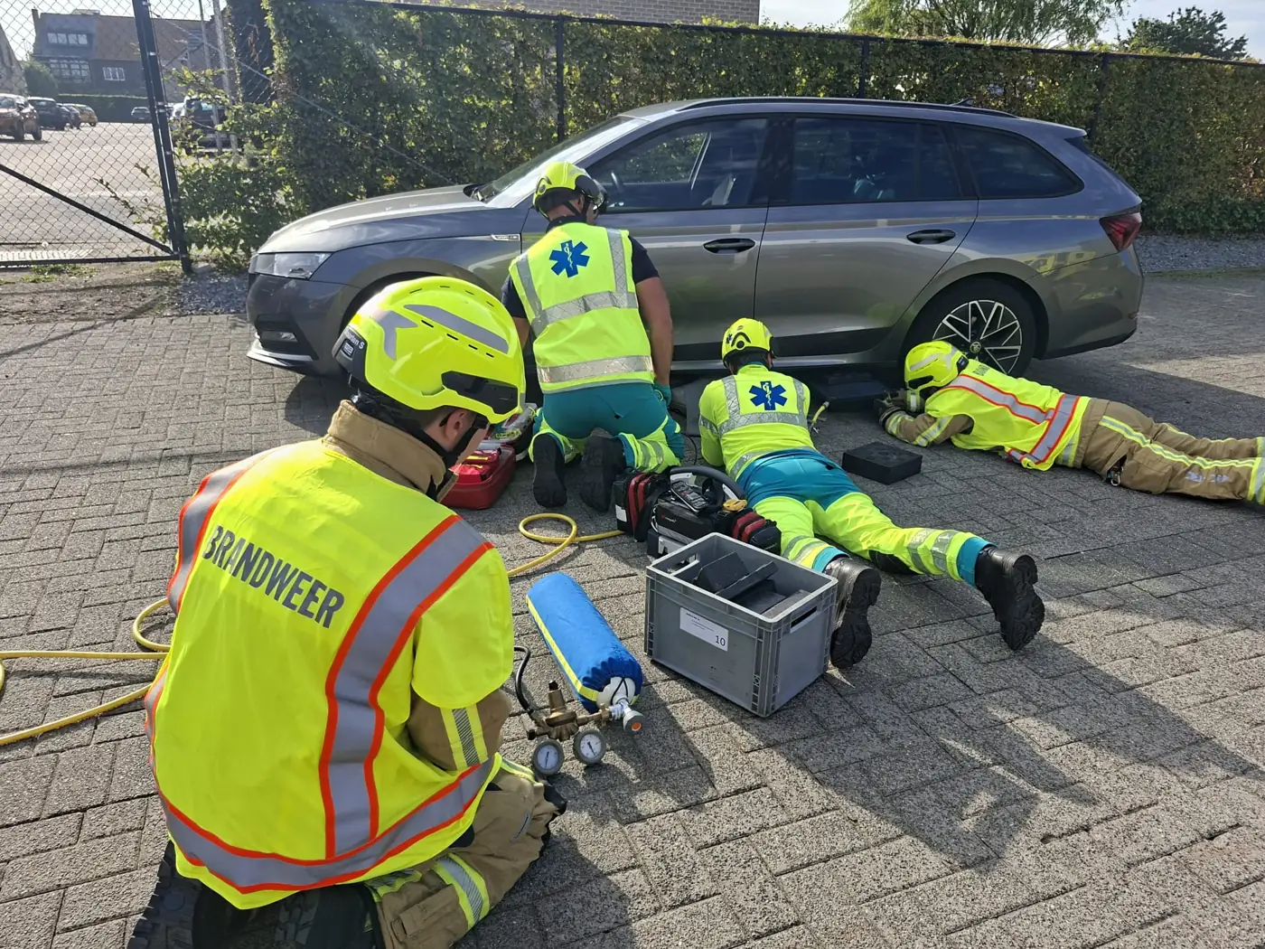 Brandweer en ambulanciers oefenen samen een redding onder een auto