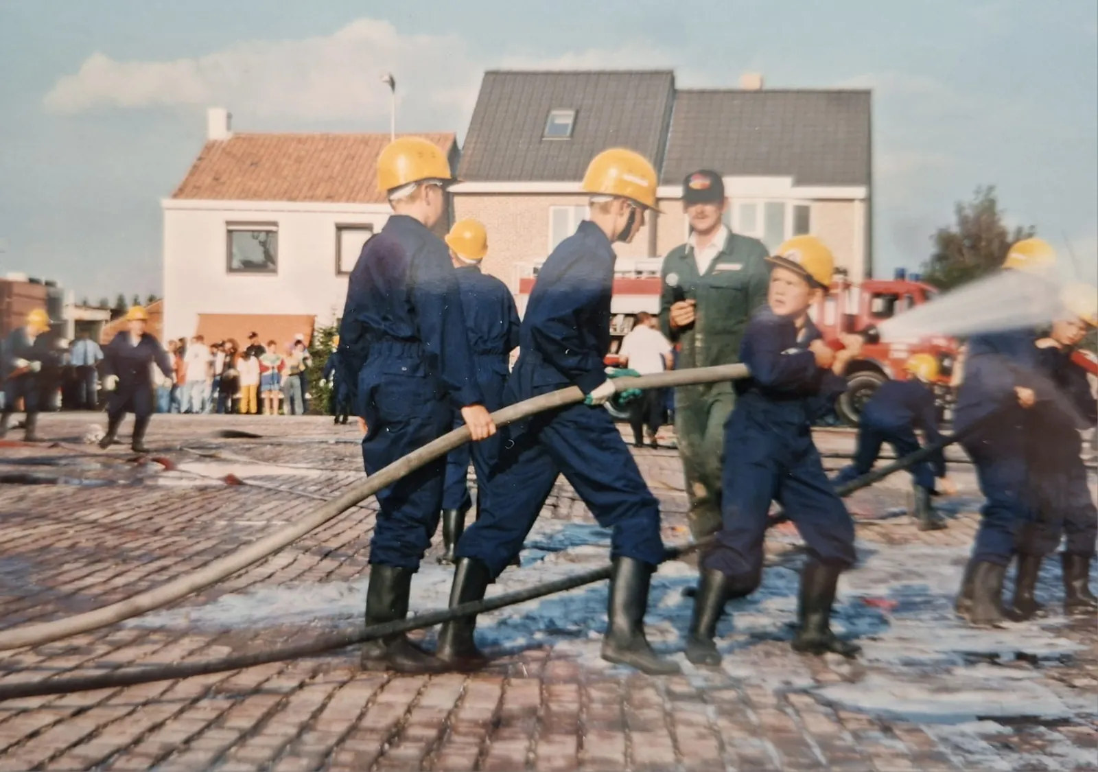 Jeugdbrandweerleden oefenen met een brandslang